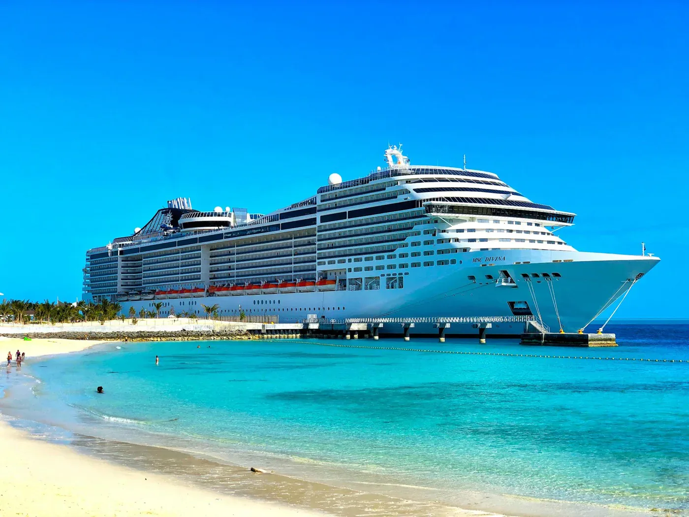 Large cruise ship docked in a tropical port with turquoise water